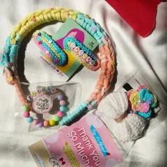 A personalized hamper for a girl named Zainab. This set includes custom name clips, a beaded bracelet, a braided headband, and crochet hair ties.