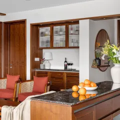 In our 'Gulmohar' project, this niche was transformed into a versatile bar and crockery space. The unit combines veneer, fluted glass, louvered shutters, and a marble buffet top for a vintage feel.