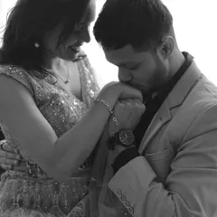 A classic black and white shot of the groom kissing the bride's hand. This timeless pose is full of romance and elegance.