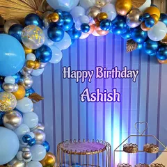 A handsome blue, silver, and gold themed birthday setup for Ashish. The decor features a striped backdrop and an elegant balloon arch with confetti and chrome balloons.