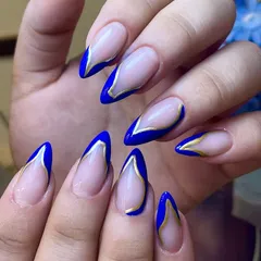Gold-lined confidence, worn on your fingertips. This sharp almond set features a bold cobalt blue V-French tip, outlined in gold for a modern and regal look.