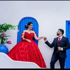 A romantic dance between a couple. The illusion long sleeves and detailed floral embroidery on this red ball gown add a touch of classic elegance to their pre-wedding photos.