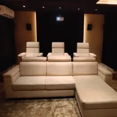 A closer look at the seating arrangement in this custom media room. The combination of a large sofa and individual recliners provides a versatile and comfortable environment for long movie marathons or casual viewing.