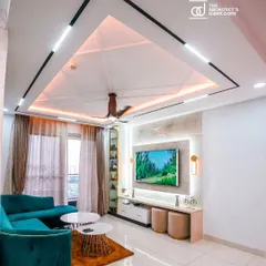 A modern living room designed for comfort and conversation. I focused on creating a sophisticated look with a striking false ceiling featuring geometric patterns and layered lighting, a plush teal sofa for a pop of color, and a sleek, minimalist TV unit. This space perfectly balances style and functionality.