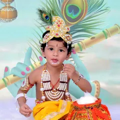 A toddler dressed as Krishna, complete with a peacock feather, flute, and a pot of butter. The custom illustrated backdrop adds a magical touch to these festive portraits.