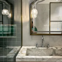A peek at a bathroom in progress. The combination of marble, green tiles, and brass accents is already creating a luxe and moody vibe.