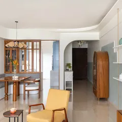 This view showcases the open and flowing layout of the home. From the entryway, you can see through to the dining nook and living area, with custom wooden furniture and soft, textured walls creating a cohesive and welcoming journey through the space.