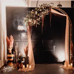 This floral archway served as a beautiful photo backdrop. I used a mix of fresh and dried flowers, including pampas grass, draped with soft fabric and surrounded by candles to create a dreamy, ethereal focal point.