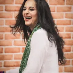 A candid photo filled with laughter against a brick wall. The joy you see here is the same joy I aim to bring to your sangeet practice.