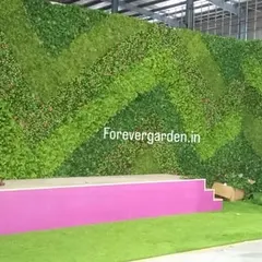 Another view of the event stage backdrop, showing the scale and impact of a custom-designed artificial green wall. It completely transforms an industrial space.
