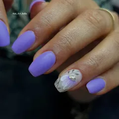 A chic matte purple set with a translucent accent nail featuring a delicate floral design.