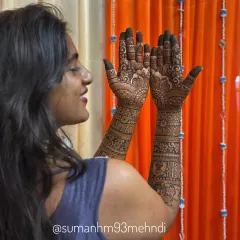 A side profile view showing how the intricate henna design wraps beautifully around the forearm. This full coverage bridal mehndi is packed with details, from fingertips to elbow.