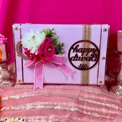 This beautiful pink trunk box is one of our most loved Diwali hampers. It's adorned with a floral arrangement and a 'Happy Diwali' cutout, making it a perfect festive gift.