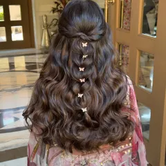 For a more whimsical and playful vibe, especially for a Mehendi or Haldi, I love incorporating fun accessories. This half-up style features a delicate butterfly braid, creating a look that is youthful, fresh, and full of personality.