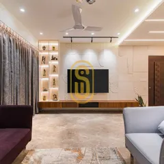This living room TV unit features a textured wall with fan-shaped carvings and a long wooden console. An illuminated display niche on the side adds a personal touch, showcasing decorative items.