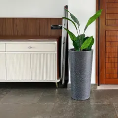 This artificial Bird of Paradise plant in a grey stone-finish planter adds a tropical feel to this home entrance without any need for watering or sunlight.