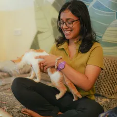 A participant enjoys a playful moment with a ginger and white kitten during our "Paint with Kittens" event in Bangalore.