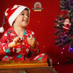 The pure joy of Christmas. This little boy's happy laugh is infectious in our festive red Christmas setup.