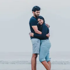 A warm, comforting hug in the shallow waters of the sea, showcasing a moment of quiet connection between the couple.