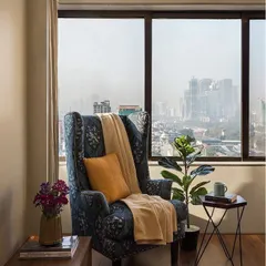 We all need a quiet corner. This reading nook, with its comfortable wingback chair and stunning city view, was designed as a personal escape within the home.