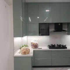 Another angle of the completed sage green kitchen, highlighting the handleless drawers and cabinets that contribute to its sleek, modern aesthetic. This project was delivered on time with our factory-finished guarantee.