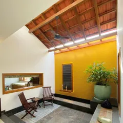 This semi-open seating area is illuminated by a long skylight set into the traditional tiled roof. The design allows for abundant natural light while protecting from the elements, creating a perfect transitional space.