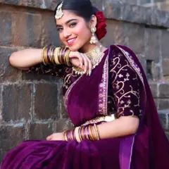 This bride chose a luxurious purple velvet saree for her reception. The look is completed with a classic floral bun, a statement choker, and glowing makeup.