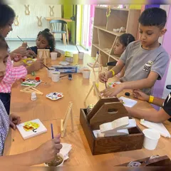 A group of children completely absorbed in their canvas painting activity. Our workshops are a great way for kids to express their creativity.
