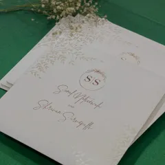 Classy and minimal. This invitation features a simple, elegant design with a beautiful script and a subtle botanical motif, all on high-quality textured paper.