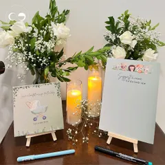 A clean and simple setup for the guest activity table at an in home baby shower. The minimalist design, with fresh flowers and soft candlelight, creates a welcoming space for guests to leave their wishes.
