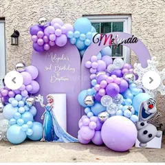 A magical Disney's Frozen theme for a birthday and baptism party. This outdoor setup includes custom arched backdrops in purple, character cutouts of Elsa and Olaf, and a balloon arrangement in an icy palette of purple, blue, and silver.