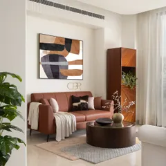 This cozy nook within the Casa Zen living area features a comfortable tan leather sofa and abstract art. It demonstrates how I create distinct zones within a larger space, each with its own mood, while maintaining a cohesive design narrative through color and material choices.