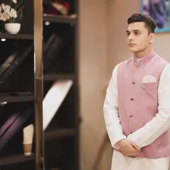 Here is a client wearing a custom-fitted pink linen Bandi over a white kurta. This combination is perfect for summer events, offering a touch of elegance without being too formal. The silver brooch adds a personalized, stylish detail.