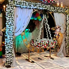 A beautiful Krishna-themed naming ceremony stage at our Kalyan banquet hall. The setup includes a decorated floral cradle, character cutouts, and a well-lit stage, perfect for capturing precious family moments.