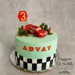Kachow! This Lightning McQueen cake was a hit with little Advay. It's a 2.5 kg Vanilla Caramel cake with a hand-molded fondant McQueen, cacti, and a checkered flag border.