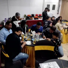 Guests at a baby shower focused on a writing-based party game. I offer a mix of activities, including quizzes and creative challenges that engage the mind.