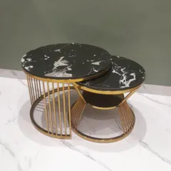 This set of two nesting center tables features a stunning black marble top with white veining. The gold electroplated steel base adds a touch of luxury, and the design can be customized to fit your space.