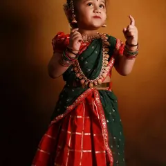 Another adorable shot of the custom-designed kids' half-saree. The combination of red and green with the temple jewelry is a classic South Indian look.