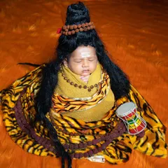 A serene portrait of a newborn dressed as Lord Shiva, complete with the tripundra on his forehead and a tiger print wrap.