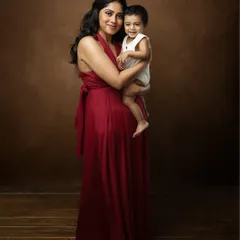 A beautiful fine art portrait of a mother and her child. Her elegant red dress and their loving embrace create a timeless image, perfect for a framed print.