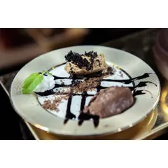 A decadent hazelnut platter, featuring different textures of chocolate and hazelnut mousse, artfully arranged on a golden plate. Desserts are the fairy tale of my kitchen.