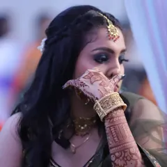 A candid shot of a client during a sangeet night. I created a glamorous look with bold, smokey eyes and a braided hairstyle, perfect for an evening of celebration.