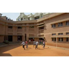 The Buddhi School in Bengaluru is designed around a large, shaded courtyard that serves as the heart of the campus. The building's orientation and use of earth blocks create a comfortable, passive-cooled environment for outdoor activities and learning.