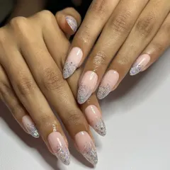 A delicate and dreamy look with a soft pink base and a fade of fine silver glitter at the tips of these long stiletto nails.
