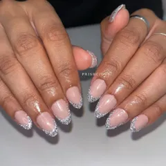 Reflective Frenchies are so much fun. This look features a classic French tip shape, but filled in with a super sparkly silver reflective glitter on acrylic extensions.
