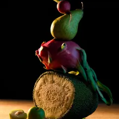 This still life sculpture from my "Fru-Veg" series features a balanced stack of jackfruit, dragon fruit, and a pear. The dark background and focused lighting give it a dramatic, almost classical art feel.