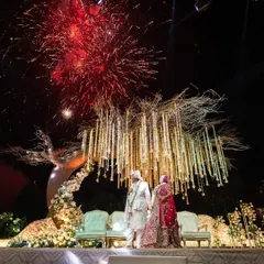 As fireworks light up the night sky, the couple shares a quiet moment on their wedding stage. We coordinate every element, including spectacular pyrotechnics, to create a grand finale for your ceremony.