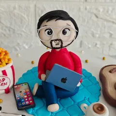 A close-up of the handcrafted fondant figurine of Ayush, complete with glasses and a laptop. I love capturing these personal details to make each cake unique.