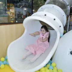 Whee. A guest enjoys the rush of our enclosed spiral slide, which ends in a soft landing in the ball pit. Our play structures are designed for maximum fun and safety.