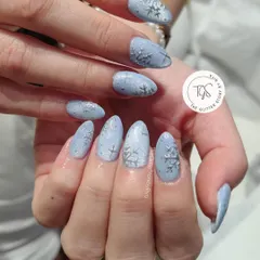 A perfect winter manicure featuring a frosty light blue base with delicate, hand-painted silver snowflakes. The textured finish gives the look of freshly fallen snow.